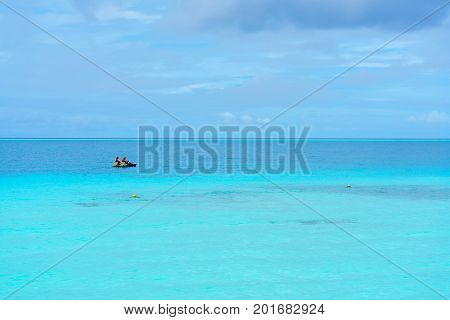 Romantic couple steering paddleboat on the crystal clear turquoise sea in the beautiful day at Maldives Island