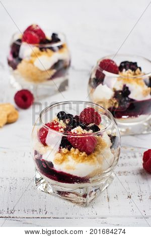 Homemade dessert in glass jars. Cheesecake, trifle, mouse on white wooden background. Copy space