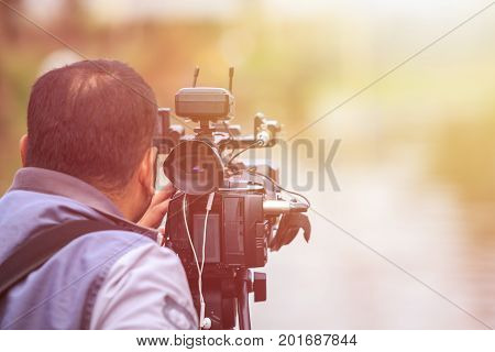 Cameraman Using Professional Digital Video Camera. Outdoor Setup And Working