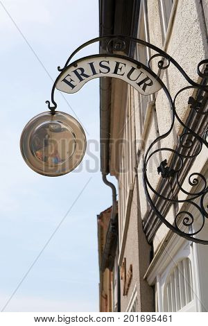 Guild sign for a hairdresser in the old town of Tangermuende in Germany