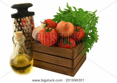 Colorful fresh ingredients seasoning and tool for cooking tomato souse. Organic tomatoes garlic onion plain parsley in wooden crate olive oil handhold kitchen shredder over white background