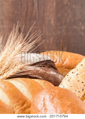 Close up view of differnet bread on brown wooden background. Copy space. Shallow DOF. Vertical.