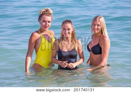 Three dutch girls standing together in sea water