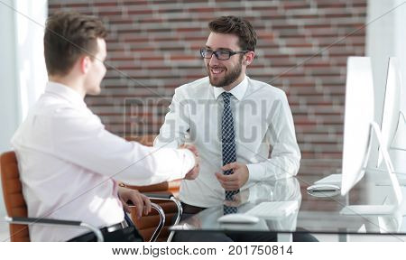 handshake colleagues sitting at your Desk