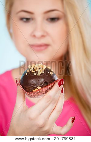 Woman Holding Chocolate Cupcake About To Bite