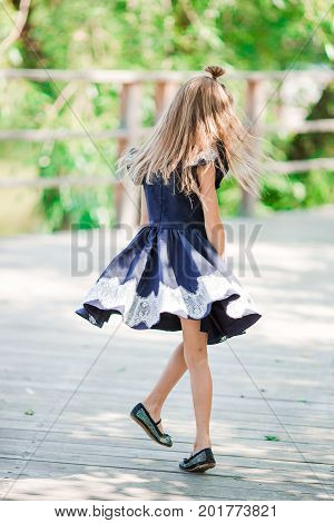 Adorable little school girl with notes and pencils outdoor.