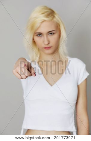 Young girl showing finger, pointing on you.