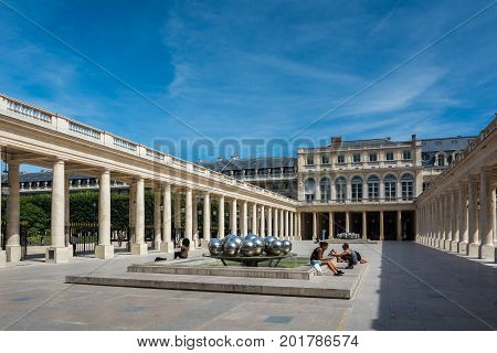 Paris France - August 13 2016: Tourists inside the Palais-Royal originally called the Palais-Cardinal is a palace located in the 1st arrondissement of Paris. The screened entrance court faces the Place du Palais-Royal opposite the Louvre.