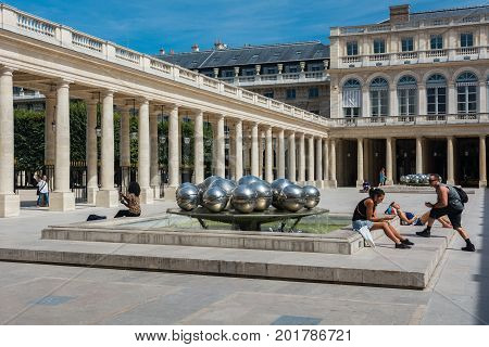Paris France - August 13 2016: Tourists inside the Palais-Royal originally called the Palais-Cardinal is a palace located in the 1st arrondissement of Paris. The screened entrance court faces the Place du Palais-Royal opposite the Louvre.