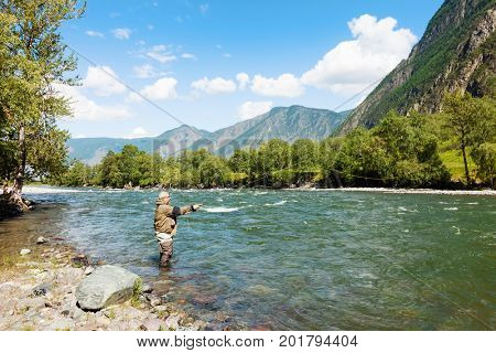 Fishing by flyfishing on the river. Russia Siberia. River Chelushman