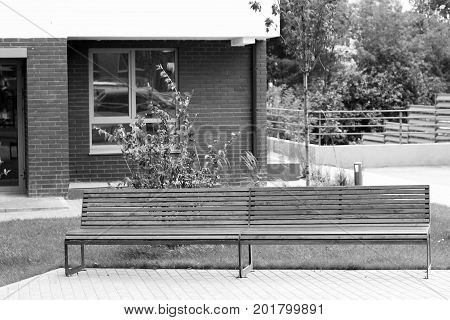 Park Bench In A Spring Garden. New Modern Courtyard.