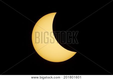 The sun with a prominent group of sunspots is partially covered by the moon during the total solar eclipse in August 2017.
