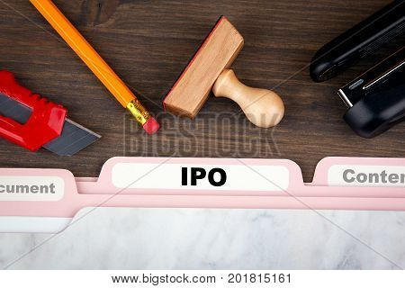 IPO Initial Public Offering. Folder Register on a dark wooden desk.