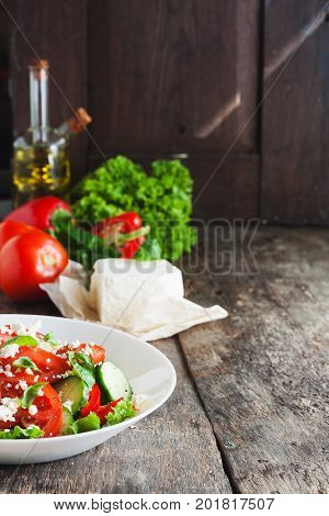 Shopska Salad In A White Plate On A Wooden Background, A Number Of Raw Ingredients Lettuce.