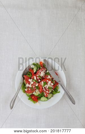 Shopska Salad In A White Plate On A White Tablecloth. The Concept Of Minimalism