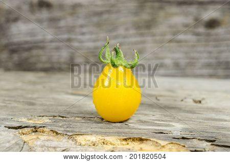 Fresh yellow cherry tomato on wood background