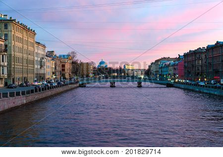 SAINT PETERSBURG RUSSIA - MAY 1 2017: Evening view of embankment of Fontanka River. On background - Cathedral of Holy Life-Giving Trinity of Life Guards Izmailovsky Regiment (Trinity-Izmaylovsky Cathedral Trinity Cathedral)