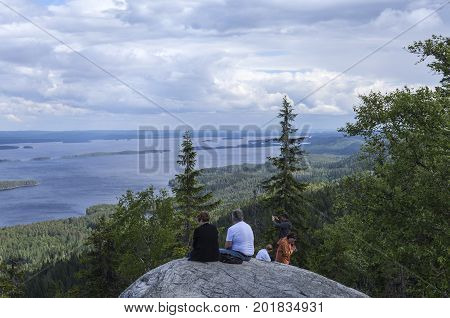 UKKO-KOLI HILL, FINLAND ON JULY 05. View of lake Pielinen from a rock, cliff on July 05, 2017 in Ukko-Koli Hill, Finland. Unidentified people at the outlook. Editorial use.
