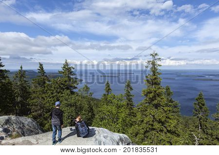 UKKO-KOLI HILL, FINLAND ON JULY 05. View of lake Pielinen from a rock, cliff on July 05, 2017 in Ukko-Koli Hill, Finland. Unidentified people at the outlook. Editorial use.