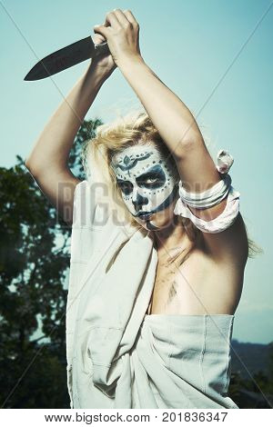 Young blonde witch during black magic woodoo ritual spelling some person through fetish doll
