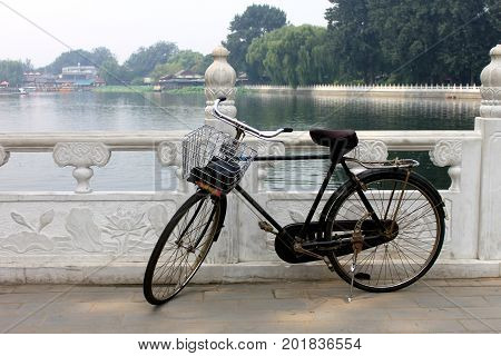 The Old Unused Bike Lay On The Railing Of Houhai Lake Park, Beijing