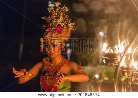 Ubud, Indonesia - August 8, 2016: Beautiful balinese woman dances during a traditional Kecak Fire Dance ceremony in Hindu temple.