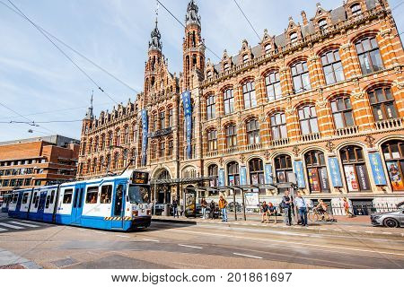 AMSTERDAM, NETHERLANDS - August 07, 2017: View on the crowded street with Magna Plaza. This building is the Former Amsterdam main post office, currently a shopping mall