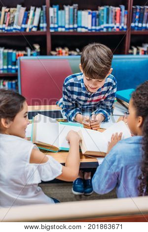 cute little kids reading books in library