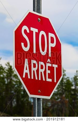 A Stop Sign Written In Both English And French