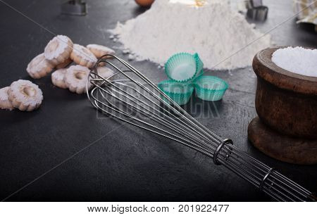 Blender whip and canestrelli Italian shortbread cookies on black table