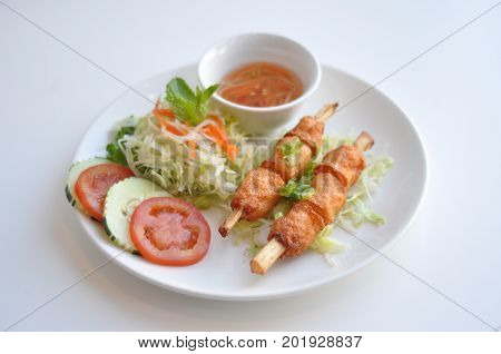 Shrimp on Sugarcane. A traditional Vietnamese dish. Shrimp paste wrapped around sugarcane and grilled. Served with fresh vegetable and homemade sauce.