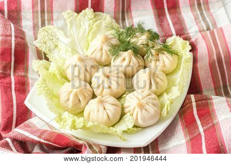 Frozen Dumplings On The White Plate With Green