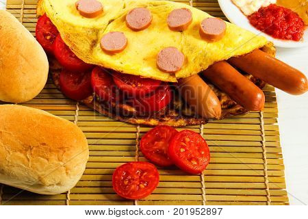Breakfast of an omelette with sausages and coffee on a white wooden background