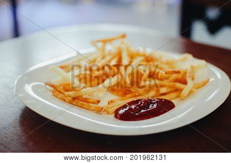 Golden French fries potatoes ready to be eaten with red sauce ketchup