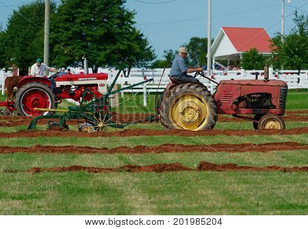 DUNDAS, PRINCE EDWARD ISLAND, CANADA - 25 Aug: Competitors plow with amtique tractors at the PEI Plowing Match and Agricultural fair on August 25, 2017 in Dundas, Prince Edward Island.