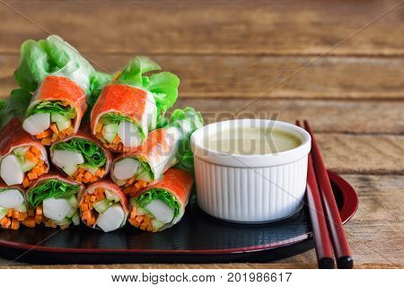 Fresh spring rolls with fresh vegetable and crab stick served with wasabi mixed salad cream dipping sauce. Rolls salad or fresh spring roll in Japanese style healthy tasty food for appetizer or meal. Fresh spring rolls in fusion food style.