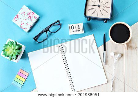 Business, weekend, holiday or new year planning concept : Top view or flat lay of open notebook paper, accessories, cube calendar and coffee cup on wooden background, ready for adding or mock up