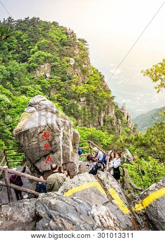 Lushan Jiangxi China, 26 April 2018 : Vertical View Of Chinese Tourists Posing Next To A Big Rock In