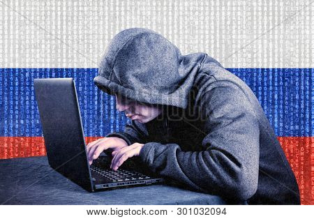 Russian hooded computer hacker with laptop 