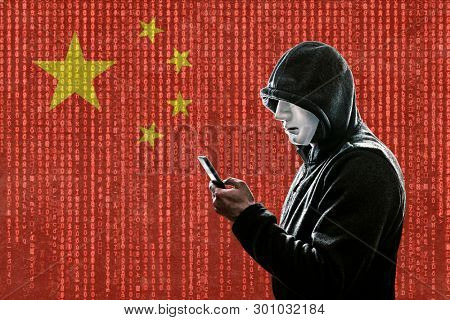Chinese hooded hacker with mask holding smartphone 