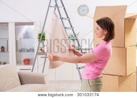 Woman chosing wallpaper for flat renewal 