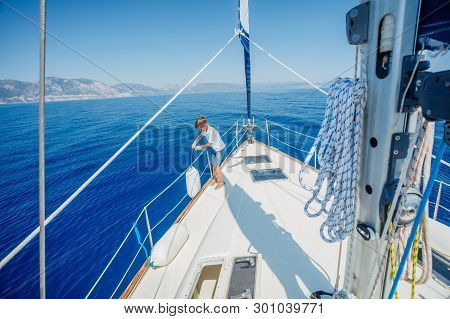 Little Boy On Board Of Sailing Yacht On Summer Cruise. Travel Adventure, Yachting With Child On Fami
