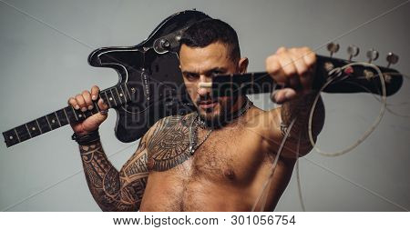 Guitar Player At Rock Concert. Sexy Abs Of Tattoo Man Hold Broken Electro Guitar. Sport And Fitness.