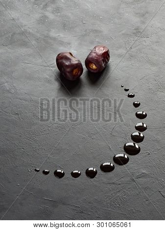 Black Ramadan Background With Dates And Dates Syrup Poured In The Shape Of Crescent Moon.