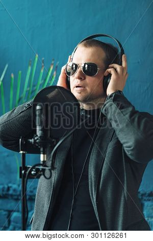 Close Up Of A Man Singer In A Headphones Recording A Song In A Home Studio