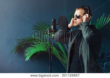 Close Up Of A Man Singer In A Headphones Recording A Song In A Home Studio