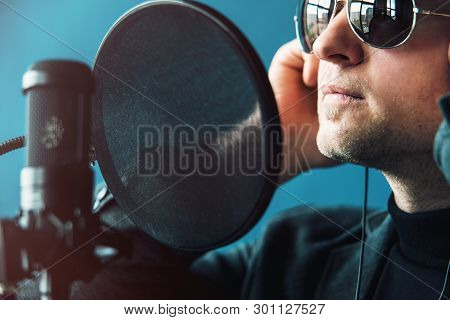 Close Up Of A Man Singer In A Headphones Recording A Song In A Home Studio