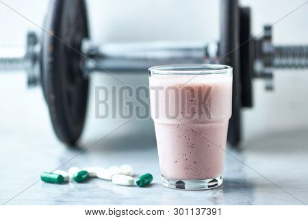 Glass Of Protein Shake With Milk And Raspberries. Bcaa Amino Acids, L - Carnitine Capsules And A Dum