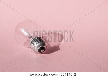 Close up view of white light bulb isolated on pink.