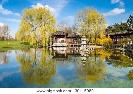 Formal Chinese Garden In Berlin, Germany. Focus On The Stone Tower In The Moddleny. Focus On The Sto